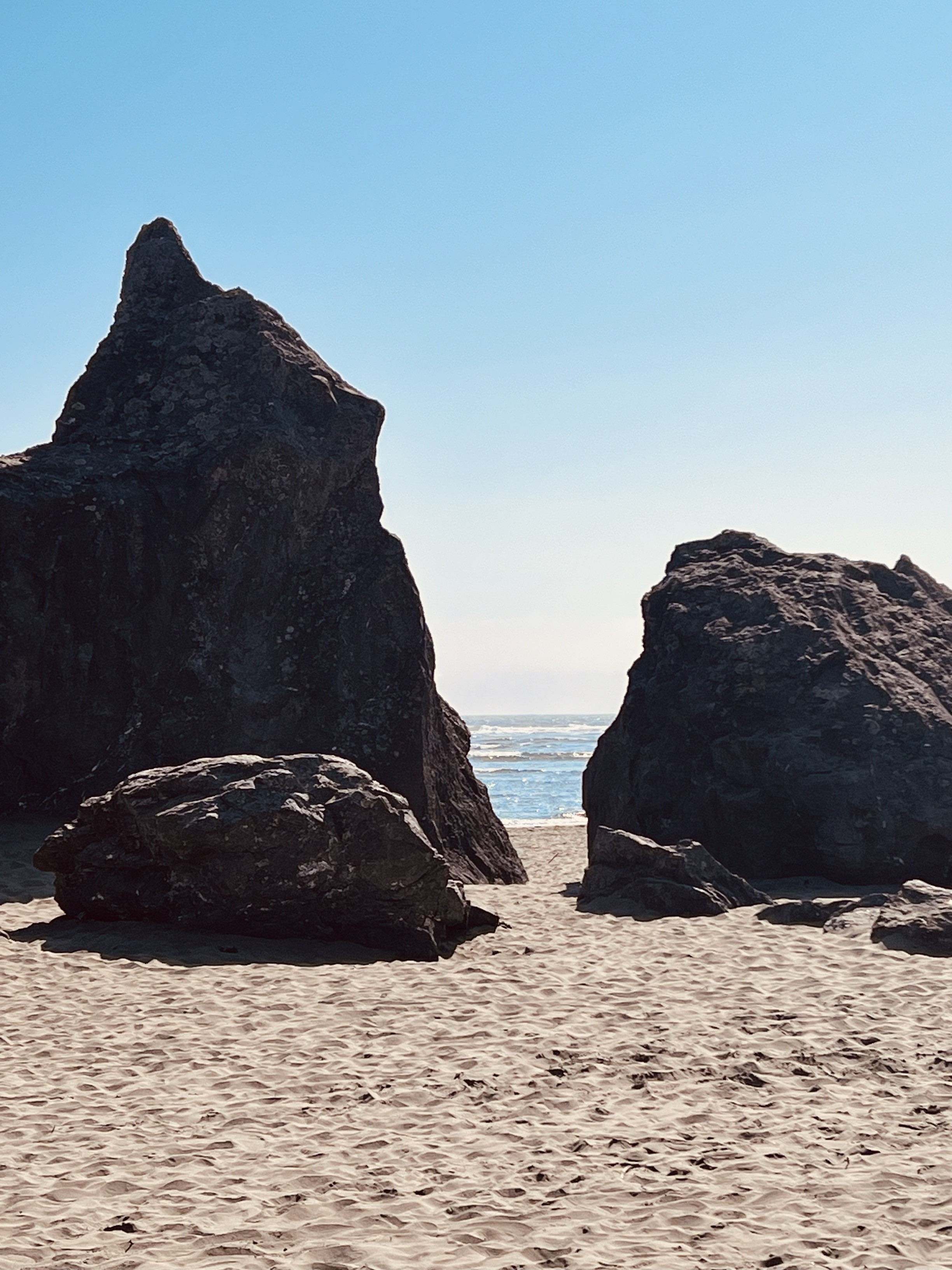 image of big boulders on a shoreline with the water seen behind them